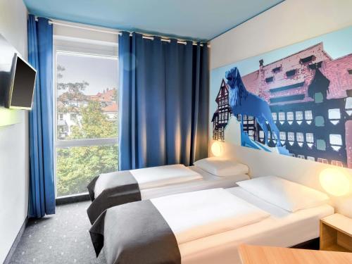 a bedroom with a bed and a large window at B&B Hotel Braunschweig-City in Braunschweig