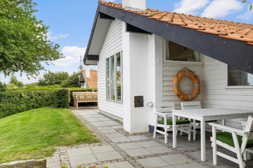 a white house with a table and chairs at 6619-Allinge-Markvejen-45 in Allinge