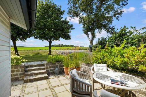 a patio with a table and chairs and a field at 6619-Allinge-Markvejen-45 in Allinge