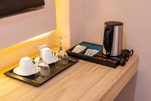 a coffee maker and glasses on a tray on a counter at Emerald Dhaka Luxury Hotel in Dhaka