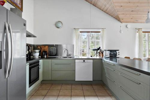 a kitchen with white and green cabinets and appliances at 3709-Nexo-Pynten-3 in Neksø