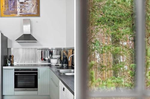 a kitchen with white cabinets and a window with a tree at 3709-Nexo-Pynten-3 in Neksø