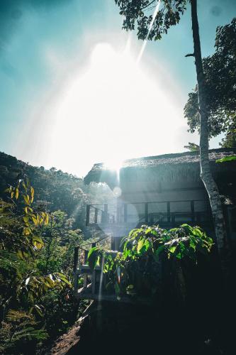 a building with the sun shining in the sky at Desa Eko in Munduk