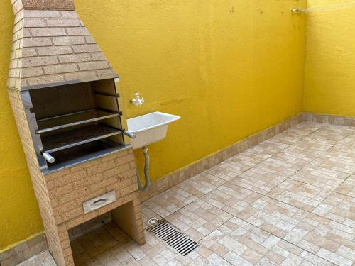 a bathroom with a sink and a yellow wall at Casa na praia 6 camas e 4 colchoes in Mongaguá
