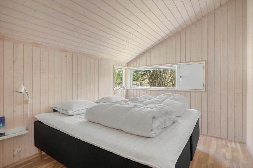 a large bed in a room with a window at 4801-Ronne-Stampen-Vej-6-Hus-7 in Rønne