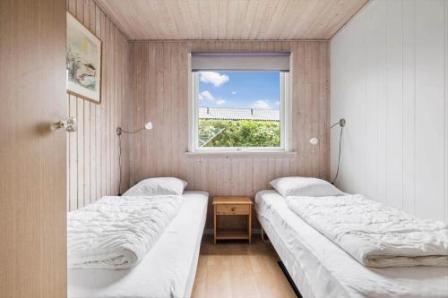 two beds in a small room with a window at 6683-Allinge-Brunekulvej-2-D in Allinge