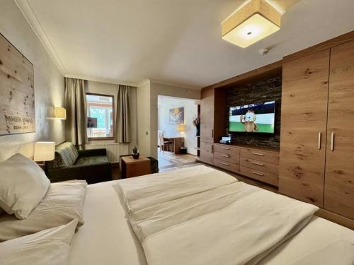 a large bedroom with a large bed and a television at Familienresort Buchau in Maurach