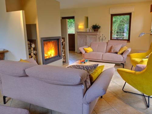 a living room with two couches and a fireplace at Chimay Nature Hideaway in Chimay