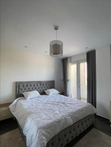 une chambre avec un grand lit et une fenêtre dans l'établissement Logement idéal pour vos séjours - 8ème étage avec ascenseur, à Birmandreis