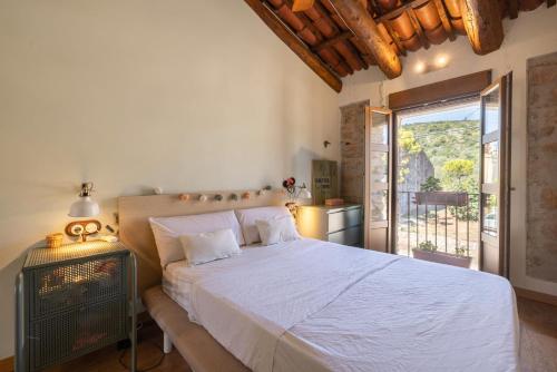a bedroom with a large bed and a balcony at Casa En Vistes Al Montsià I Prop in Ulldecona