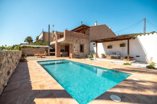 a villa with a swimming pool in front of a house at Casa En Vistes Al Montsià I Prop in Ulldecona