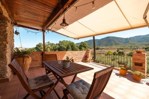 an outdoor patio with a wooden table and chairs at Casa En Vistes Al Montsià I Prop in Ulldecona