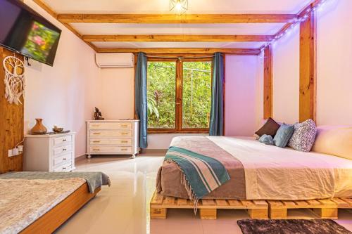 a bedroom with two beds and a window at 2 Magical Villas with Yoga Shala up to 23 guests in Patos