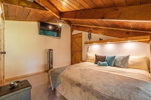 a bedroom with a large bed in a room with wooden ceilings at 2 Magical Villas with Yoga Shala up to 23 guests in Patos