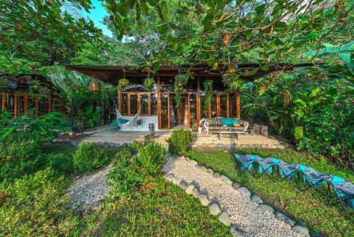 a garden with a bench and a pavilion at 2 Magical Villas with Yoga Shala up to 23 guests in Patos