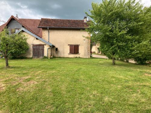 a house with a yard with two trees in front of it at Gîte Du Poisson Rouge in Molamboz