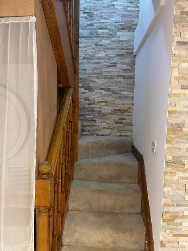a staircase in a house with a brick wall at 4-Bed Barnwell Retreat- Sleeps 9 Garden & Parking in Stevenage
