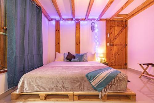 a bedroom with a large bed with purple lighting at 2 Magical Villas with Yoga Shala up to 23 guests in Patos
