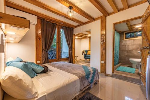 a bedroom with a large bed and a bathroom at 2 Magical Villas with Yoga Shala up to 23 guests in Patos