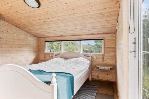 a small bedroom with a bed in a wooden house at OH526-Hadsund-Ved-Fruerlund-32 in Hadsund