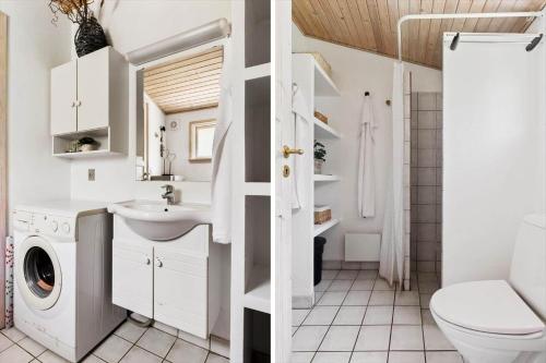 a bathroom with a toilet sink and a washing machine at OH526-Hadsund-Ved-Fruerlund-32 in Hadsund