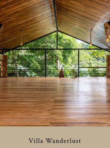 a room with a wooden floor and a wooden deck at 2 Magical Villas with Yoga Shala up to 23 guests in Patos