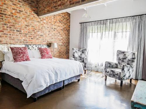 - une chambre avec un lit et un mur en briques dans l'établissement Rustique Boutique Hotel, à Middelburg