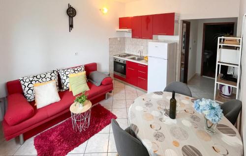 a living room with a red couch and a table at Amazing Apartment In Supetar in Supetar