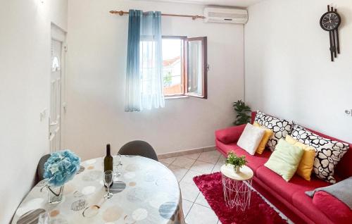 a living room with a red couch and a table at Amazing Apartment In Supetar in Supetar