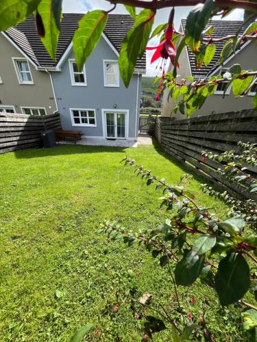 a yard in front of a white house at 2 Cois Chnoic - Dingle holiday home in Dingle