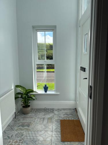 a hallway with a window and a potted plant at 2 Cois Chnoic - Dingle holiday home in Dingle
