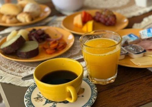 a table with a cup of coffee and plates of food at Apt para 5 pessoas em frente a vila do pescador caboclo na nova orla de Tamandaré in Tamandaré