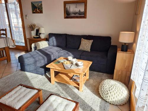 a living room with a blue couch and a table at Chalet spacieux avec vue magnifique in Saint-Marcel
