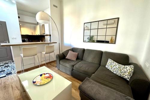 a living room with a couch and a table at Spacious cocoon close to the beach in Ajaccio