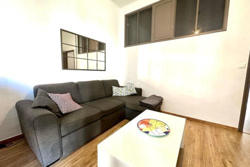 a living room with a couch and a table at Spacious cocoon close to the beach in Ajaccio