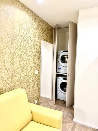 a living room with a yellow couch and a washing machine at Hotel Astigiana & Appartamenti in Varazze
