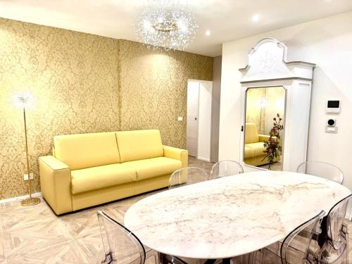 a living room with a yellow couch and a table at Hotel Astigiana & Appartamenti in Varazze