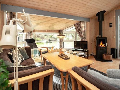 a living room with a table and a fireplace at 6 person holiday home in Saltum in Saltum