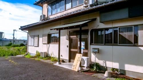 a house with a sign in front of it at 木の家ゲストハウス郡山本館 in Koriyama