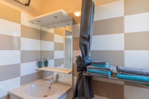 a bathroom with a sink and a mirror and towels at Gîte Chêne ou Murier in Les Vans