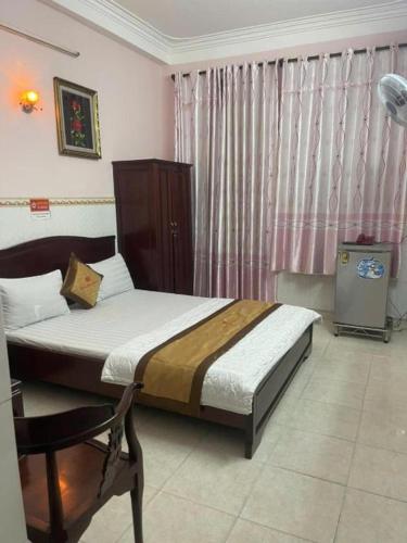 a bedroom with a bed and a window with curtains at Hotel Minh Hiếu in Ho Chi Minh City