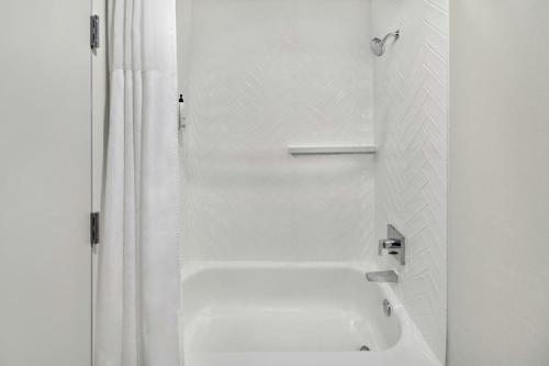 a white bathroom with a tub and a shower at Fairfield Inn & Suites Detroit Farmington Hills in Farmington Hills