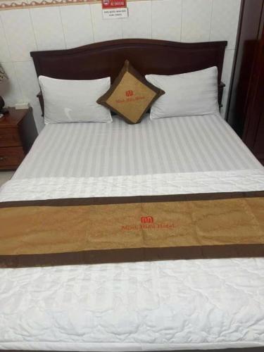 a bed with white sheets and pillows on it at Hotel Minh Hiếu in Ho Chi Minh City