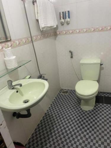 a bathroom with a white toilet and a sink at Hotel Minh Hiếu in Ho Chi Minh City