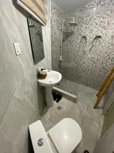 a white bathroom with a sink and a toilet at Oasis beach resort in Cape Coast