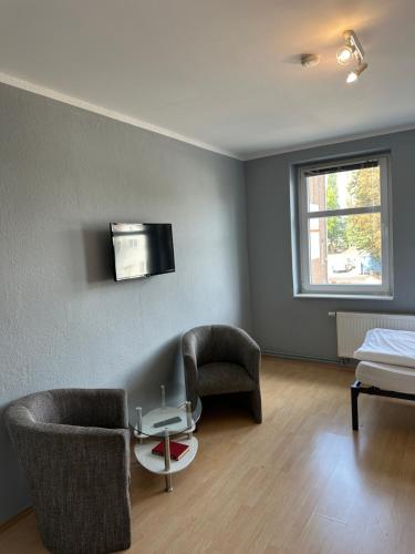 a room with two chairs and a table and a bed at 1, 2 und 3 Zimmer Monteurwohnungen in Egeln in Egeln