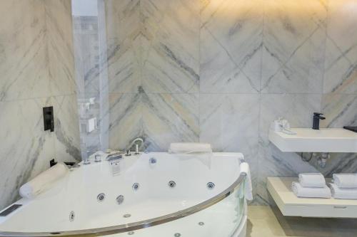 a bathroom with a tub and a sink at Emerald Dhaka Luxury Hotel in Dhaka