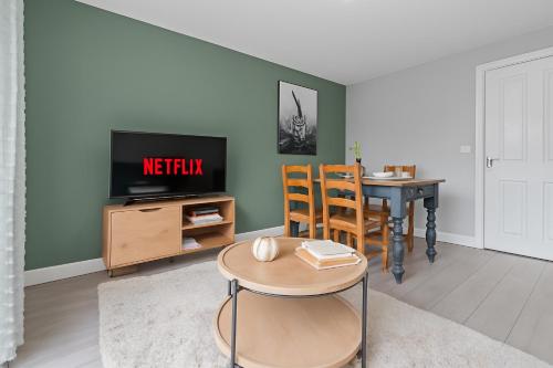 un salon avec une table et une télévision dans l'établissement Welcoming House - Walking distance to Town Centre - Sleeps 5 - Free Parking, Self-Check-In, Fast WiFi and Smart TV by Yoko Property, à Rugby