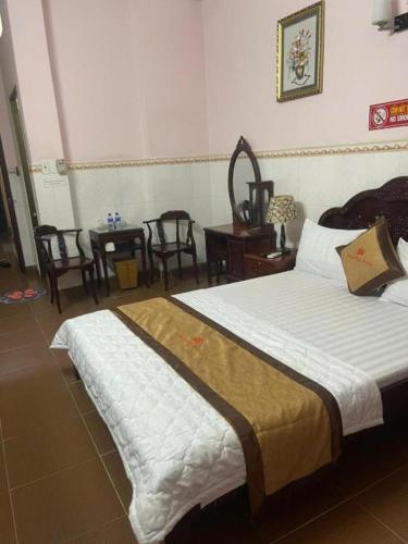 a bedroom with a bed and a table and chairs at Hotel Minh Hiếu in Ho Chi Minh City