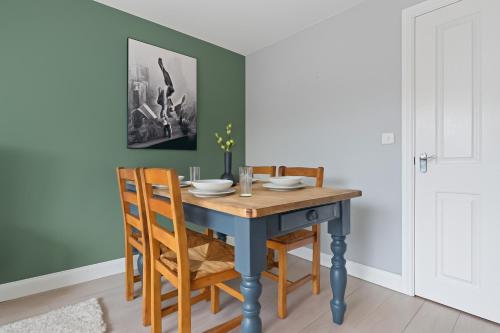 une salle à manger avec une table et des chaises bleues dans l'établissement Welcoming House - Walking distance to Town Centre - Sleeps 5 - Free Parking, Self-Check-In, Fast WiFi and Smart TV by Yoko Property, à Rugby